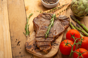 Steak with vegetables on a wooden background, restaurant and hotel business, menu, homemade recipes, culinary background, horizontal photo, banner