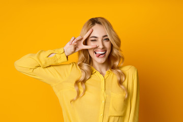 Pretty Girl Winking, Showing Tongue and Peace Gesture