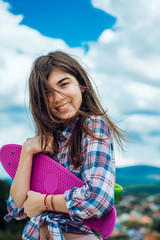 Fototapeta premium skateboard sport hobby. Summer activity. Hipster girl with penny board. Urban scene, city life. plastic mini cruiser board. Spring. ready to ride on the street. happy girl. Feeling free and happy