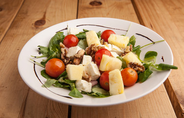 Healthy pineapple , tomato cherry , nuts and canons salad .