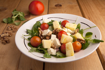 Healthy pineapple , tomato cherry , nuts and canons salad .