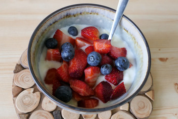 Homemade Yoghurt with Fresh Strawberries and Blueberries on a Wooden Background
