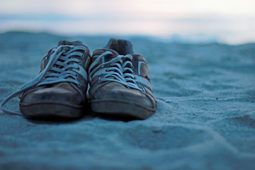 Outworn shoes in sand at beach © ramonr