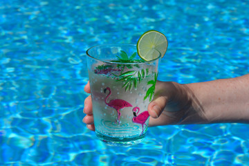 hand holding glass of water with lime
