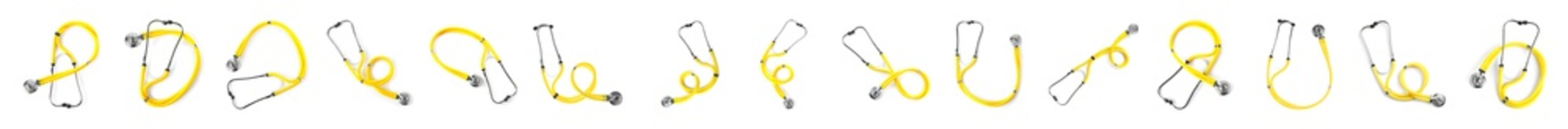 Set of yellow stethoscopes on white background, top view. Medical device