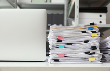 Laptop and documents on desk in office