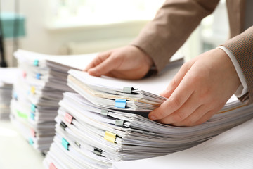 Woman working with documents at table in office, closeup