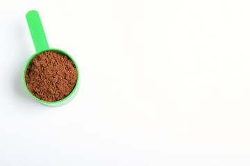 Scoop of protein powder on white background, top view