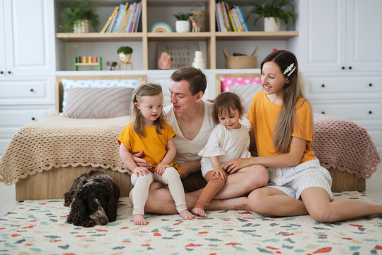 Child With Down Syndrome With Family Indoors