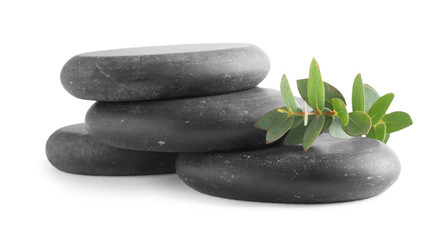 Stack of black spa stones with eucalyptus isolated on white
