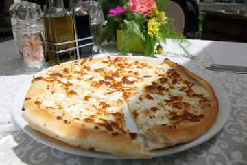 Flat Cheese Bread in a White Plate on a Restaurant Table