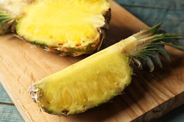 Cut fresh juicy pineapple on wooden board, closeup