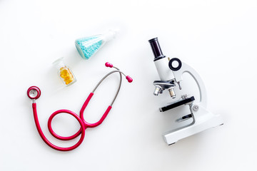 Medical research with microscope, stethoscope, test tube on white background top view