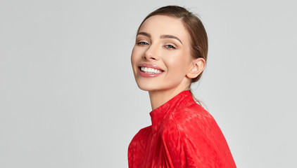 Portrait of smiling blonde woman isolated on gray background