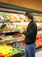 Young man buying vegetables at the market