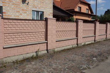 Fototapeta na wymiar private long brown brick fence on a city street