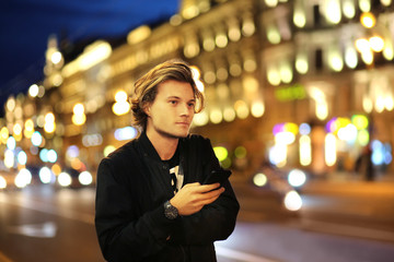 Lifestyle portrait of a teenage boy using a smart phone outdoors