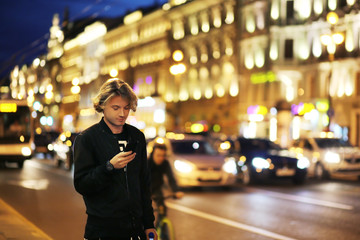 Lifestyle portrait of a teenage boy using a smart phone outdoors