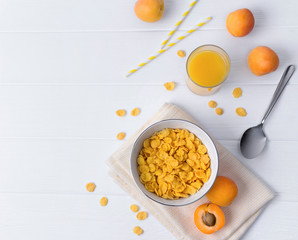 Corn Flakes with apricot at the white wooden table.