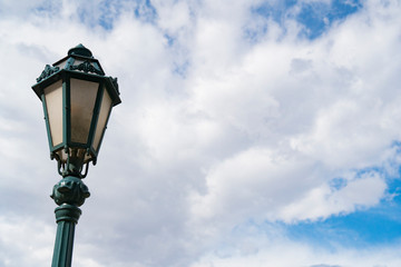 Fototapeta na wymiar Lamp Post in a Blue Sky with White CLouds