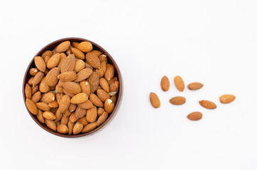 Brown wooden bowl full of almond on white background shot from abowe