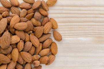 Close up of a pile of almonds on a wooden background