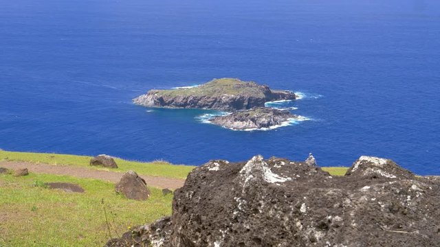 CLOSE UP: Scenic view from above of small rocky islands near Easter Island. Picturesque view of an islet that was used for ancient bird man rituals. Islet of Motu Nui is surrounded by deep blue ocean.