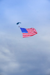 person parachuting with american flag flying in wind