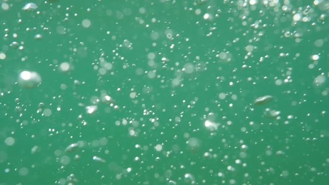 Bubbles rising to the surface. Slow motion. Air bubbles in clear blue water (underwater shot), good for backgrounds.