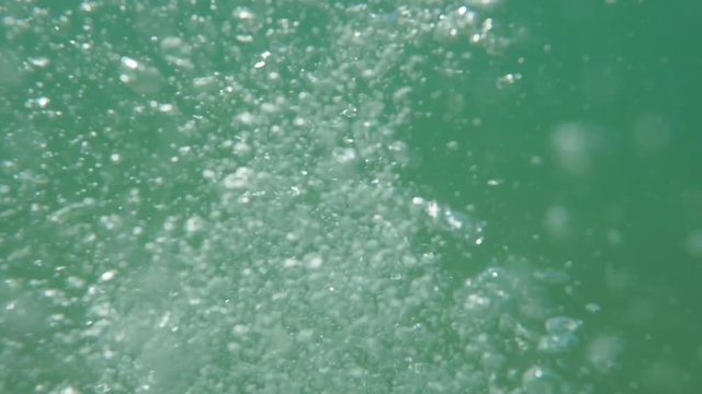 Bubbles rising to the surface. Slow motion. Air bubbles in clear blue water (underwater shot), good for backgrounds.