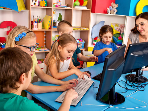 Computer education for children use computer game in class with teacher.