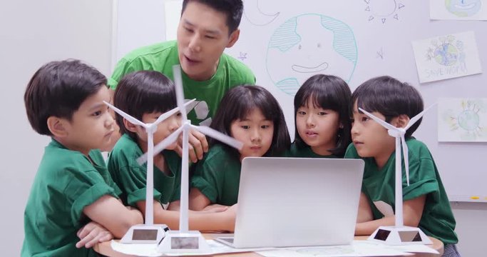 Teacher explaining to student in classroom about ecology project. Technology and Education concept.