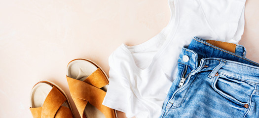 Woman's casual summer vacation outfits with white t-shirts, denim shorts, trendy leather sandals,...