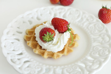 Waffle with Cream and Strawberries in a White Plate isolated on a White Background