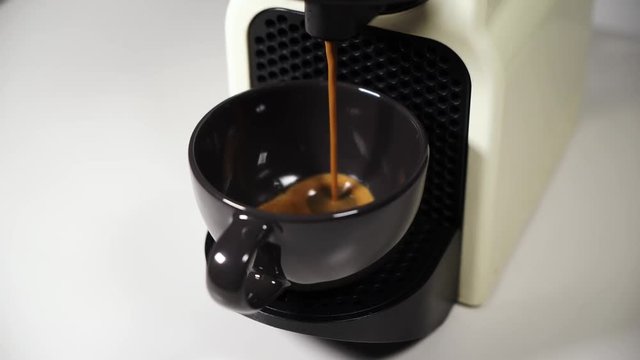 Close-up shooting of a coffee machine pouring into glass cup
