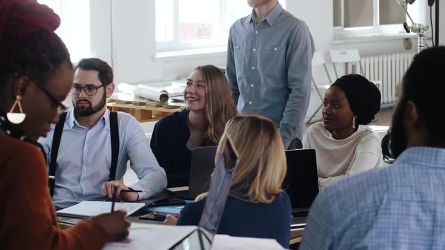 Happy multiethnic smiling business group listen to marketing seminar at conference in modern office. Healthy workplace.