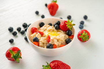 healthy breakfast with oatmeal porridge with starwberry and blueberry in a bowls
