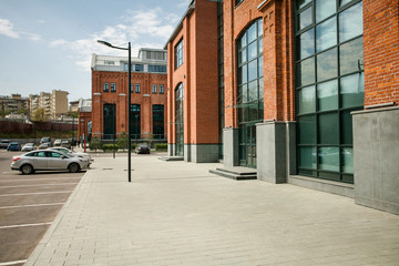 Decorative lighting pole in cityscape. Modern loft building from red brick in downtown area. Manufacture Arma in Moscow. Industrial design in city architecture. Business concept.