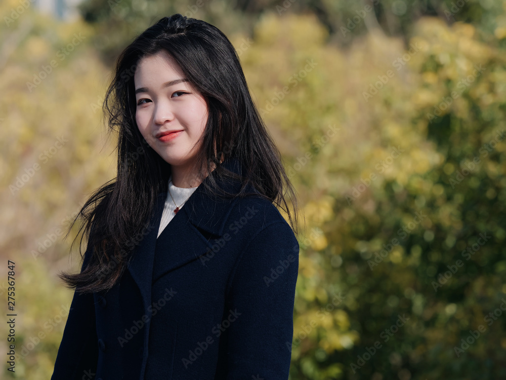 Wall mural portrait of young asian woman with black long hair, smiling and happy with nature blur forest backgr