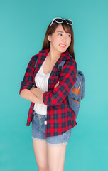 Beautiful portrait young asian woman wear sunglasses on head smile expression confident enjoy summer holiday isolated blue background, model girl fashion having backpack, travel concept.