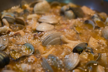 Recipe to prepare a paella: added the clams a cooking time is left