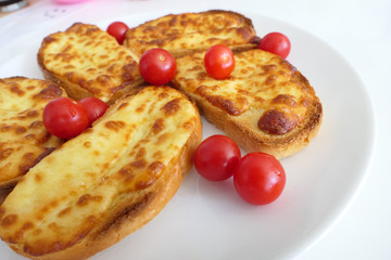 Roasted Cheese Toasts and Cherry Tmatoes in a White Plate