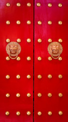 Traditional red oriental doors with golden knockers and door knobs. Summer Palace, Beijing, China.