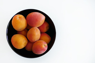 Apricots in a Black Bowl isolated on a White Background