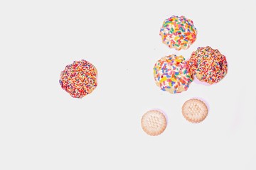 cookies on cooling rack with colorful sprinkles on white background. 