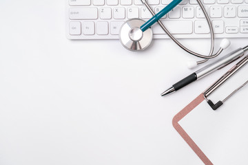 Stethoscope on keyboard on white table background. Online medical information treatment technology...