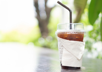 Close up glass of ice americano coffee on wood table, selective focus