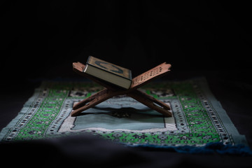 Quran - Muslim holy book placed on a wooden board