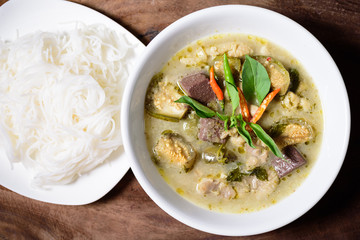 Thai green curry chicken and rice noodles in a bowl on wooden, Thai food