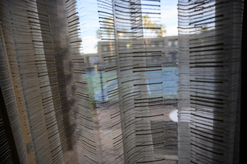 Looking through stripped window shades at a hotel basketball court